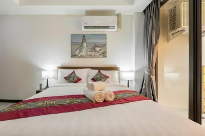 a bedroom with a bed with two towels on it at NaiHarn Pearl Condo - Pets Friendly! in Nai Harn Beach
