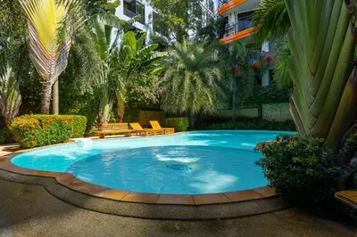 a large swimming pool in a yard with trees at NaiHarn Pearl Condo - Pets Friendly! in Nai Harn Beach