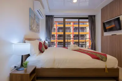 a bedroom with a white bed and a window at NaiHarn Pearl Condo - Pets Friendly! in Nai Harn Beach