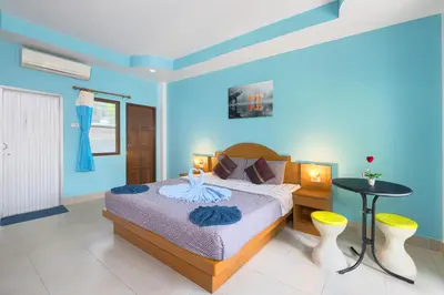 a blue bedroom with a bed and a table at Grand View in Patong Beach