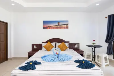 a bedroom with a large bed with blue and white sheets at Grand View in Patong Beach