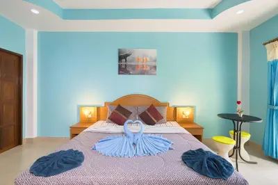 a bedroom with a bed with two blue towels on it at Grand View in Patong Beach