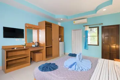 a bedroom with a bed and a desk and a television at Grand View in Patong Beach