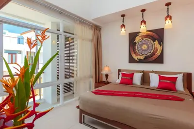 a bedroom with a bed and a large window at Genesis Villas in Rawai Beach