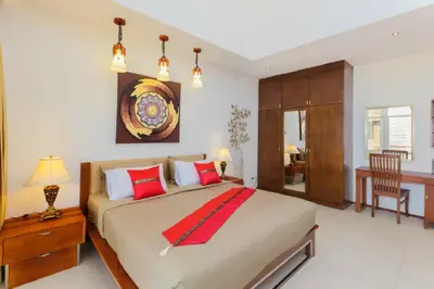 a bedroom with a large bed with red pillows at Genesis Villas in Rawai Beach