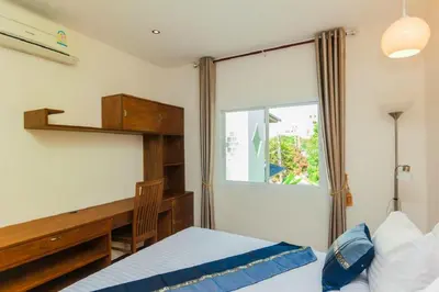 a bedroom with a desk and a bed and a window at Genesis Villas in Rawai Beach