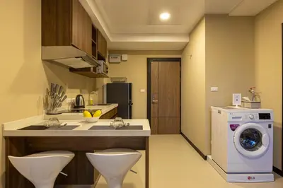 a kitchen with a washing machine and a washer at NaiHarn Pearl condo by Holy Cow, 1-BR, courtyard view in Nai Harn Beach