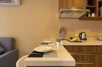 a small kitchen with a table with plates on it at NaiHarn Pearl condo by Holy Cow, 1-BR, courtyard view in Nai Harn Beach