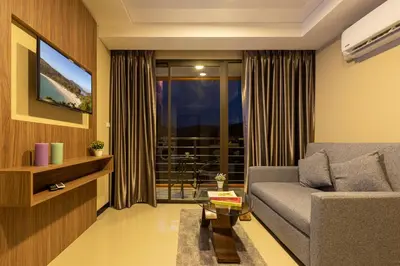 a living room with a couch and a window at NaiHarn Pearl condo by Holy Cow, 1-BR, courtyard view in Nai Harn Beach