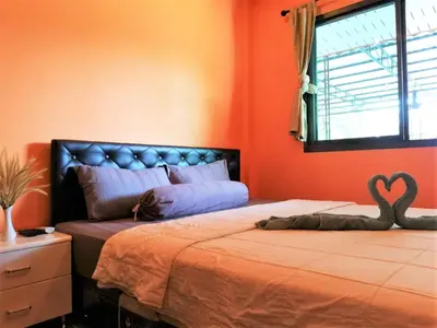 a bedroom with a bed with a heart pillow on it at Phurafa Resort in Phang-nga