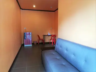 a room with a blue couch and a table at Phurafa Resort in Phang-nga