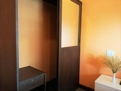 a bathroom with a mirror and a wooden door at Phurafa Resort in Phang-nga