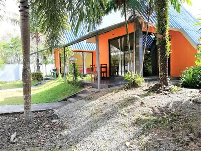 an orange house with palm trees in front of it at Phurafa Resort in Phang-nga
