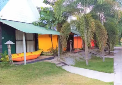 a house with two palm trees in front of it at Phurafa Resort in Phang-nga