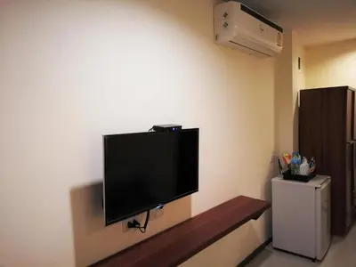 a flat screen tv hanging on a wall at Laemsai Resort in Thalang