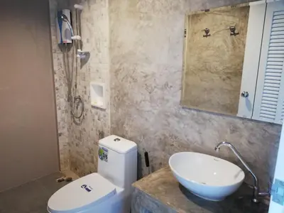 a bathroom with a white toilet and a sink at Laemsai Resort in Thalang