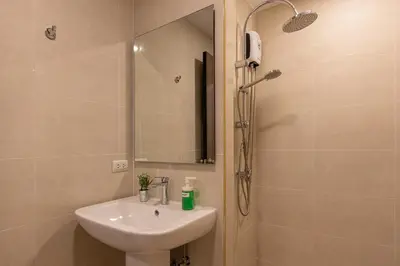 a bathroom with a sink and a shower with a mirror at NaiHarn Sea Condo by Holy Cow, 1-BR, courtyard view in Nai Harn Beach