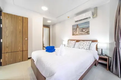 a bedroom with a large bed with white sheets at SOLA Condo 1BR Tropical View NBC Nai Harn Nai in Rawai Beach