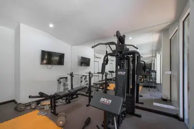 a gym with several tread machines in a room at SOLA Condo 1BR Tropical View NBC Nai Harn Nai in Rawai Beach