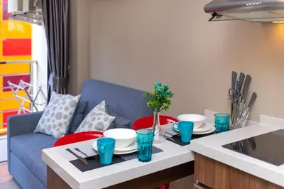 a living room with a table and a blue couch at SOLA Condo 1BR Tropical View NBC Nai Harn Nai in Rawai Beach