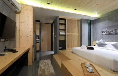 a bedroom with a large bed and a wooden desk at Relife Windy by Holy Cow, studio with podium in Nai Harn Beach