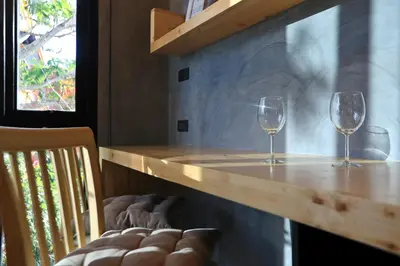 two glasses of wine sitting on a wooden table at Relife Windy by Holy Cow, studio with podium in Nai Harn Beach