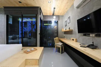 a bedroom with a bed and a desk with a television at Relife Windy by Holy Cow, studio with podium in Nai Harn Beach