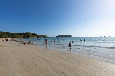 a group of people swimming in the water on a beach at Relife Windy by Holy Cow, studio with podium in Nai Harn Beach