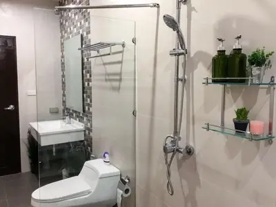 a bathroom with a shower and a toilet and a sink at Koh Sirey Beachfront Pool Villa in Phuket Town