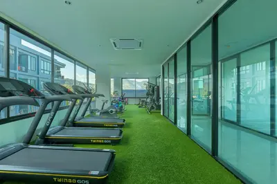 a row of treadmills in a gym with green grass at Relife Windy by Holy Cow, country view in Rawai Beach