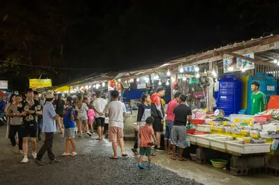 a crowd of people standing around a market at night at Relife Windy by Holy Cow, country view in Rawai Beach