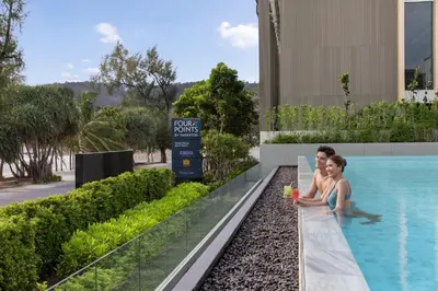 a rendering of two people standing next to a swimming pool at Four Points by Sheraton Phuket Patong Beach Resort in Patong Beach