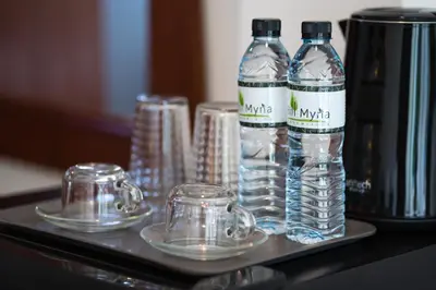 a tray with water bottles and glasses on a table at Hill Myna Holiday Park & Cafe in Bang Tao Beach