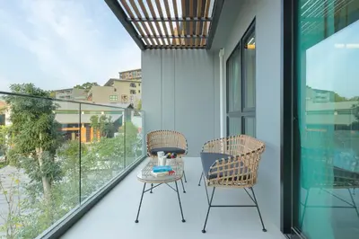 a balcony with two chairs and a glass table at Sea View Panora Surin by Holy Cow, 1-BR in Surin Beach