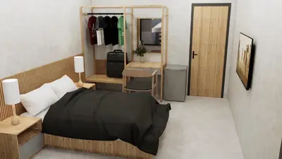 a bedroom with a bed and a table and a mirror at The Grey House Palai Phuket in Chalong