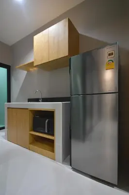 a kitchen with a stainless steel refrigerator and a microwave at The Grey House Palai Phuket in Chalong