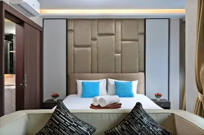 a bedroom with a bed with two towels and a bathtub at Panora Surin by Holy Cow, 1-BR, mountain view in Surin Beach