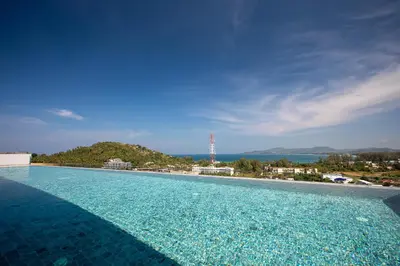 a swimming pool with a view of the ocean at Panora Surin by Holy Cow, 1-BR, mountain view in Surin Beach