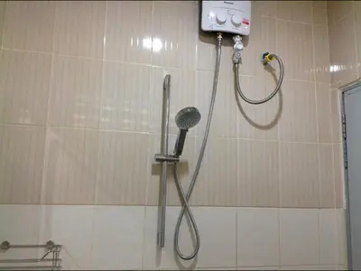 a shower in a bathroom with a shower head at Phuket Town Budget House - Aircon Room #1 in Ban Lo Long