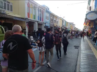 a group of people walking down a street at Phuket Town Budget House - Aircon Room #1 in Ban Lo Long