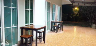 a row of tables and chairs in a room with windows at Khao Thong Home Stay in Krabi town
