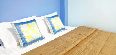 a bed with two blue and white pillows on it at Khao Thong Home Stay in Krabi town