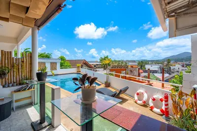 a view from the balcony of a house with a glass table at Kata Hill Sea View Hotel in Kata Beach