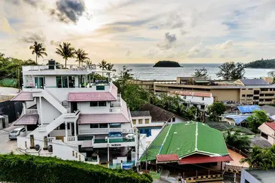 a group of buildings with the ocean in the background at Kata Hill Sea View Hotel in Kata Beach