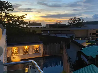 a view of a building with lights in the windows at Kata Hill Sea View Hotel in Kata Beach