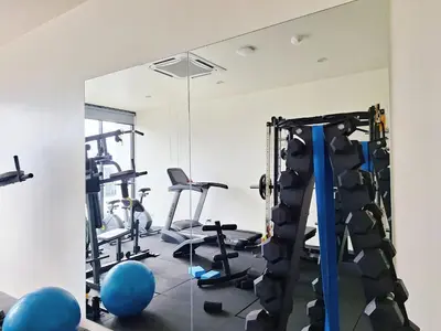 a gym with tread machines and a mirror at Dome Kata Resort in Kata Beach