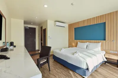 a bedroom with a large bed with a blue screen at Dome Kata Resort in Kata Beach