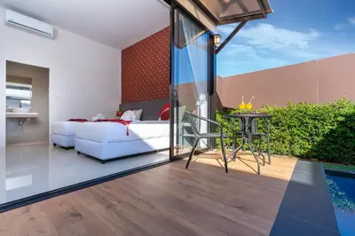 a bedroom with a bed and a table with a dining table at Thames Tara Private Pool Villa Rawai Phuket in Rawai Beach