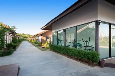 a walkway next to a building with windows at Thames Tara Private Pool Villa Rawai Phuket in Rawai Beach