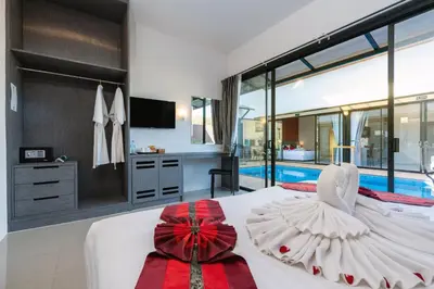 a bedroom with a large bed and a swimming pool at Thames Tara Private Pool Villa Rawai Phuket in Rawai Beach